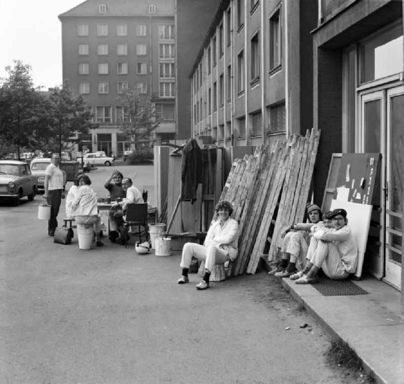 Construction workers sitting together at the rear building of Ernst-Thaelmann-Strasse (today Wilsdruffer Strasse) 14 - 16 in Dresden - Altstadt in the state Saxony on the territory of the former GDR, German Democratic Republic