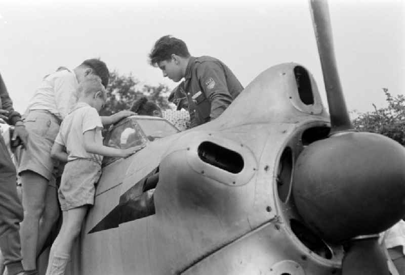 Children inspect a 'Jakowlew Yak-18' training and motorized aircraft from the GST Society for Sport and Technology on the Elbwiesen glider airfield on the Kaethe-Kollwitz-Ufer street in the Altstadt district of Dresden, Saxony on the territory of the former GDR, German Democratic Republic