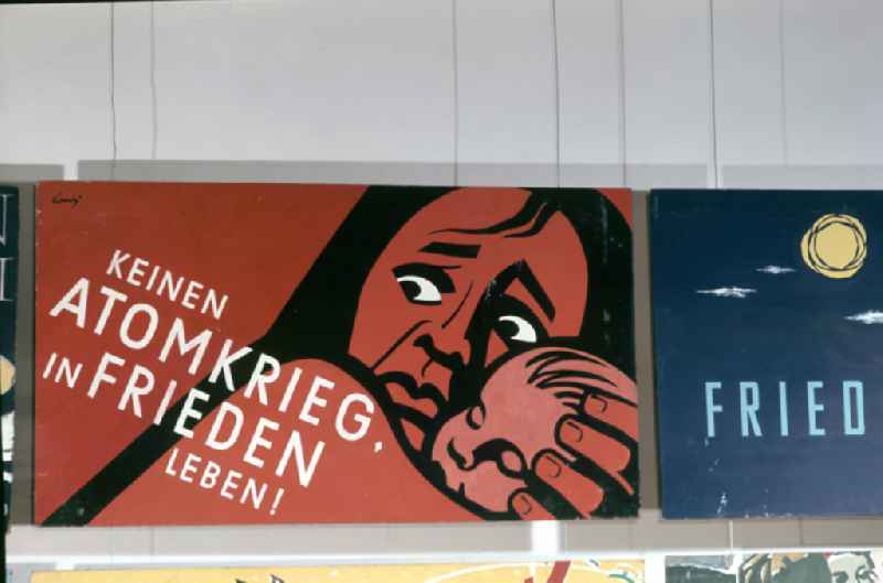 Posters protesting against the war and the nuclear threat at the IVth Art Exhibition in Dresden, Saxony on the territory of the former GDR, German Democratic Republic. The slogan 'No nuclear war, live in peace!' is written on one poster