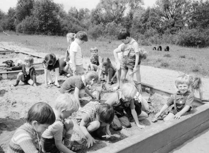 Children in day care center of VEB mill Finow playing outside in the sand box in Eberswalde in Brandenburg on the territory of the former GDR, German Democratic Republic