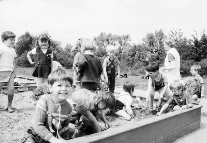 Children in day care center of VEB mill Finow playing outside in the sand box in Eberswalde in Brandenburg on the territory of the former GDR, German Democratic Republic