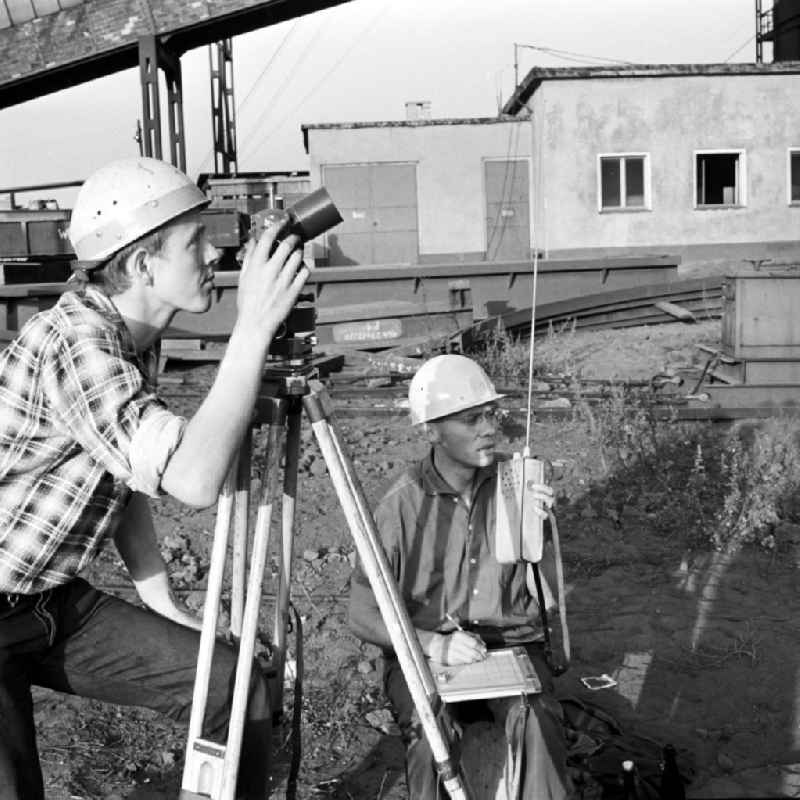 Zwei Vermessungstechniker arbeiten auf dem Werksgelände im Eisenhüttenkombinat Ost (EKO) in Eisenhüttenstadt. Am 18. August 195
