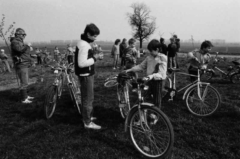 Die Klasse einer Schule im Bezirk Erfurt besucht bei einem Pioniernachmittag mit dem Fahrrad die Patenbrigade in einer Landwirtschaftlichen Produktionsgesnossenschaft (LPG). Auf dem Feld wird eine Pause / Rast gemacht.