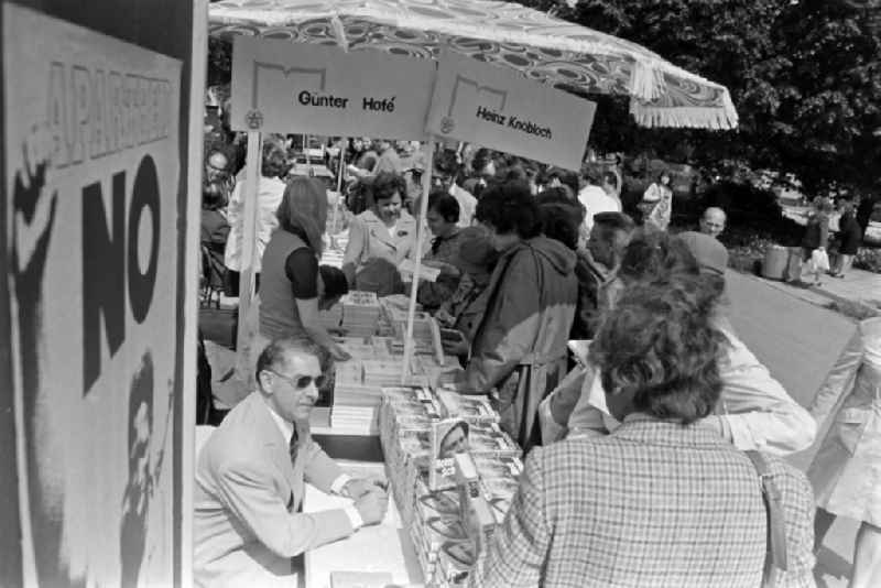 Writers' bazaar on the grounds of the IGA in the Rose Garden on the occasion of the 15th Workers' Festival in Erfurt in the federal state of Thuringia in the territory of the former GDR, German Democratic Republic. Guenter Hofé ( author ) with his books at the book bazaar