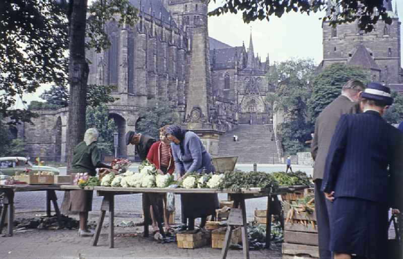 Sellers present their goods to customers on the tables of their market stallauf dem Domplatz in the district Altstadt in Erfurt, Thuringia on the territory of the former GDR, German Democratic Republic