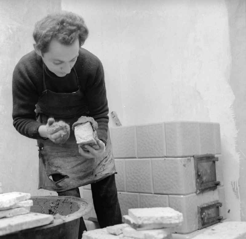 Stove fitter while putting up a tiled stove in Frankfurt (Or) in the federal state Brandenburg in the area of the former GDR, German democratic republic