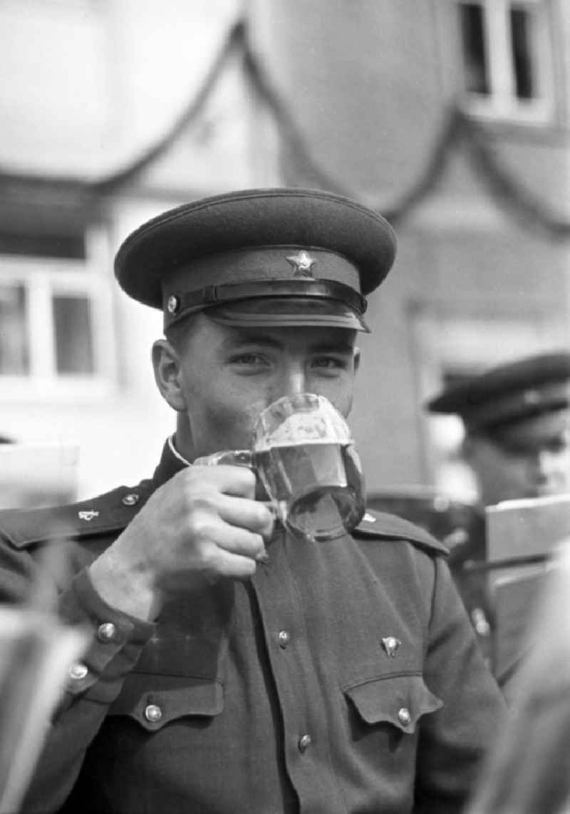 Zum Winzerfest in Freyburg an der Unstrut trinkt ein Soldat der Blaskapelle der Sowjetarmee ein Glas Bier.