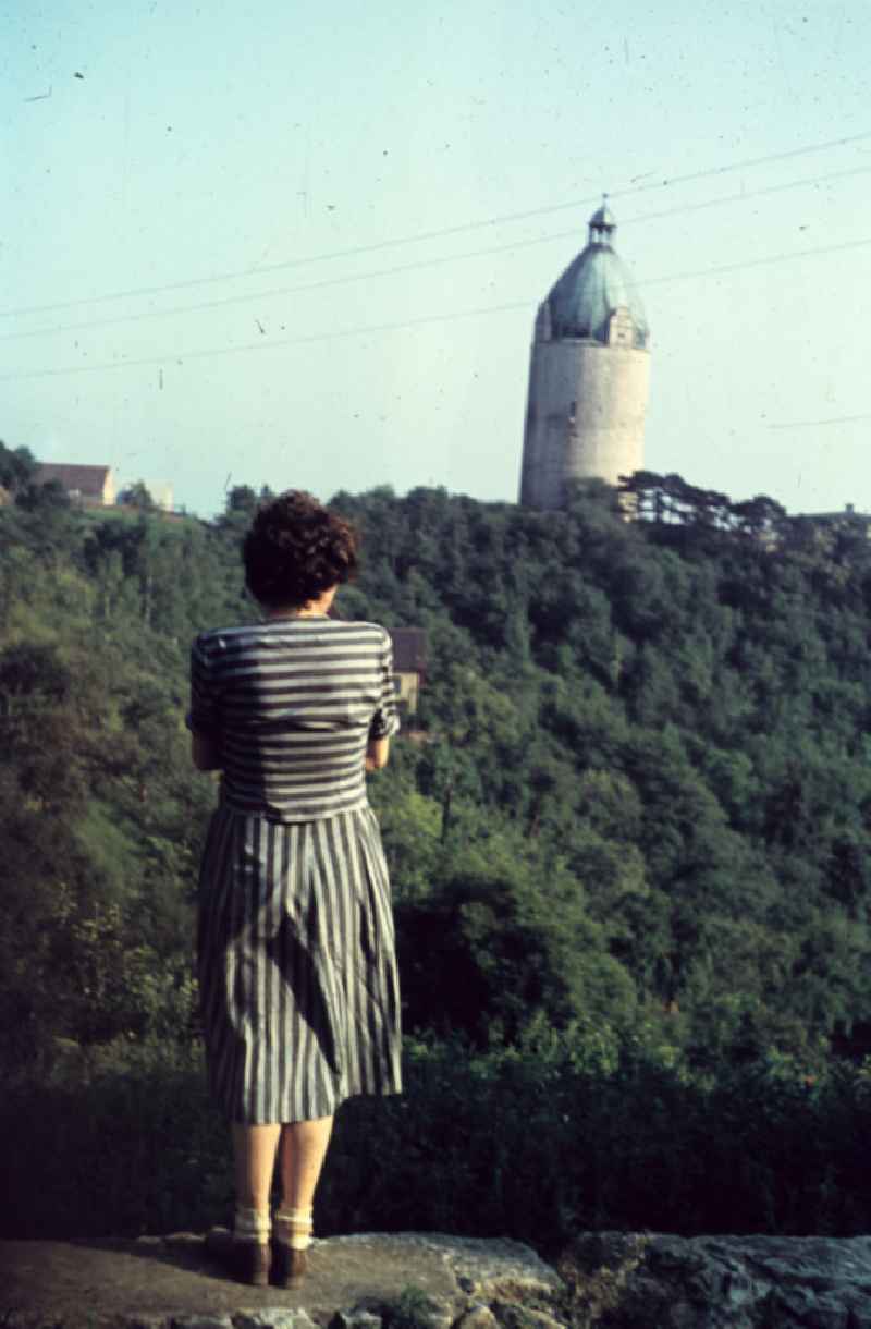 Eine Frau schaut von einer Mauer vom Schloss Neuenburg auf den Turm Bergfried 'Dicker Wilhelm'. A woman looks to a tower from a wall of the castle 'Schloss Neuenburg'.