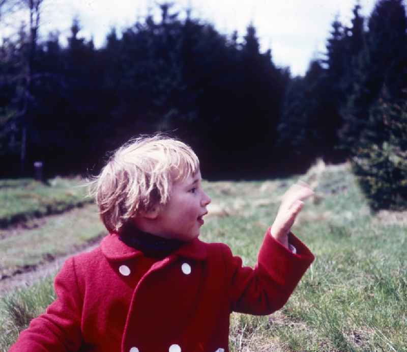 Small girl with red coat in Friedrichroda in the federal state Thuringia in the area of the former GDR, German democratic republic