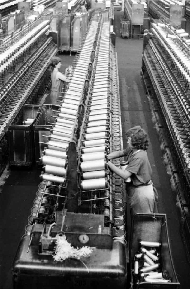 Female workers change coils on direct cabling machines for tire cord at the production plant and operating facilities of the VEB Reifenkombinat Fuerstenwalde, later Pneumant Reifen Gmbh and Goodyear, in Fuerstenwalde/Spree in the state Brandenburg on the territory of the former GDR, German Democratic Republic