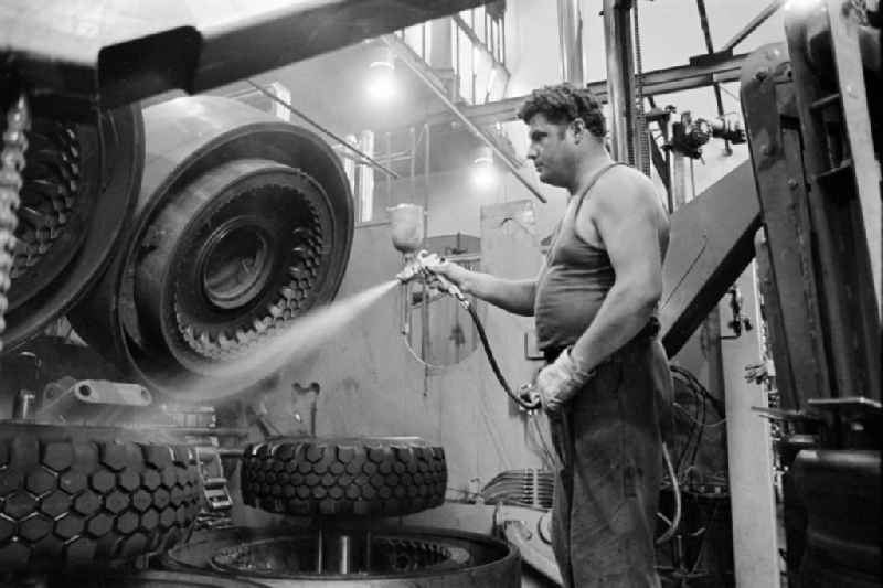 Workers in front of a tire press, shortly after joining or vulcanizing the carcass and bladder to form a finished tire in the production plant and operating facilities of the VEB Reifenkombinat Fuerstenwalde, later Pneumant Reifen Gmbh and Goodyear, in Fuerstenwalde/Spree in the state Brandenburg on the territory of the former GDR, German Democratic Republic