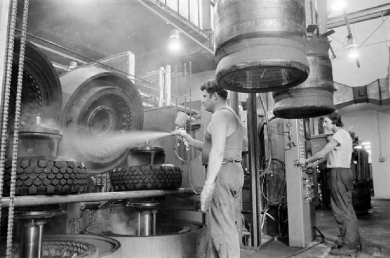 Worker in front of a tire press, shortly before joining or vulcanizing carcass and bladder to form a finished tire in the production plant and operating facilities of the VEB Reifenkombinat Fuerstenwalde, later Pneumant Reifen Gmbh and Goodyear, in Fuerstenwalde/Spree in the state Brandenburg on the territory of the former GDR, German Democratic Republic