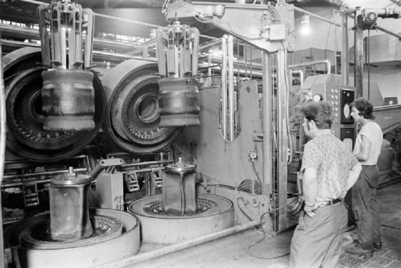 Worker in front of a tire press, shortly before joining or vulcanizing carcass and bladder in the production plant and operating facilities of the VEB Reifenkombinat Fuerstenwalde, later Pneumant Reifen Gmbh and Goodyear, in Fuerstenwalde/Spree in the state Brandenburg on the territory of the former GDR, German Democratic Republic