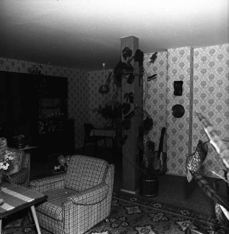 Wohnzimmer in der Neubauwohnung einer jungen Familie im Stil der siebziger Jahre. Im Hintergrund Schrankwand Typ Hellerau.
