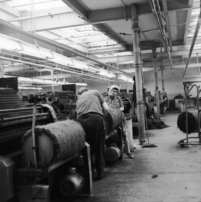 Employees on machines in the factory VEB Spinnstoffwerk Otto Buchwitz in Glauchau in the state Saxony today
