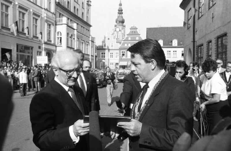 Besuch von Erich Honecker anlässlich der Domweihe St. Nikolai. Klaus Ewald, Oberbürgermeister Greifswald, übergibt Erich Honecker, Generalsekretär DDR, Dokumentenmappe. Drumherum Pressevertreter.