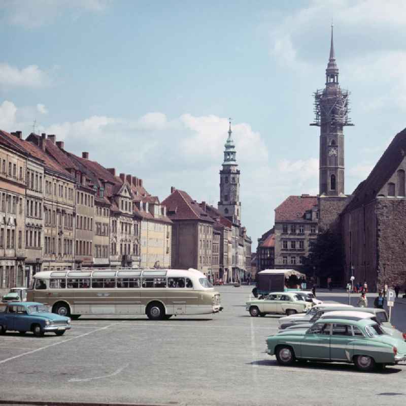 Blick auf den Obermarkt von Görlitz, der hier als Parkplatz genutzt wird. Der Bus ist vom Typ Ikarus 66, die Pkws hauptsächlich von der Marke Wartburg oder Moskwitsch. Im Hintergrund der Turm des Alten Rathauses (l) und der Turm der Dreifaltigkeitskirche.