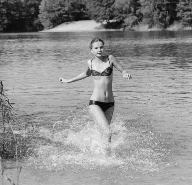 Young woman wearing a bikini in a lake in Gruenheide (Mark) in Brandenburg in the area of the former GDR, German Democratic Republic