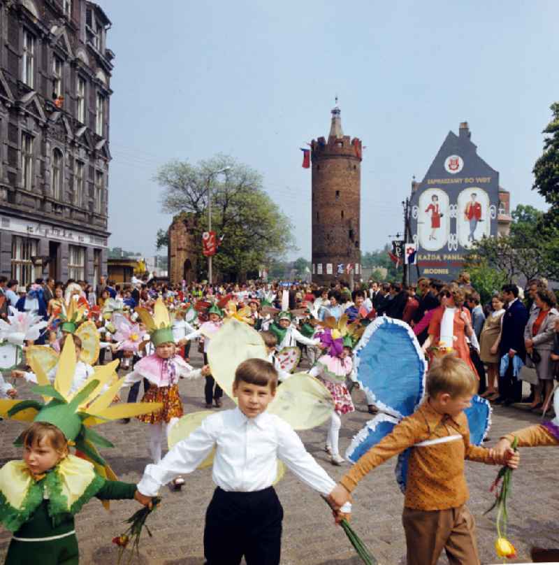 Kinder in Blumenkostümen laufen zum Frühlingsfest duch die Straßen von Gubin. Im Hintergrund der Baszta Ostrowska, der sogenannte 'Dicke Turm' der alten Stadtmauer.