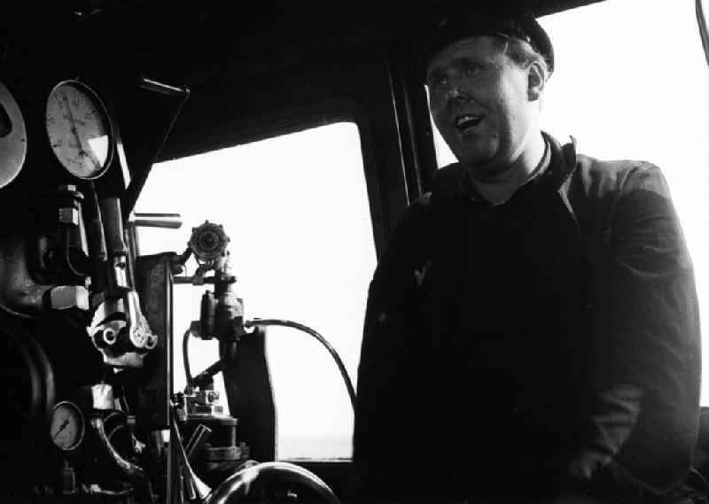 Shot of the engine driver Heinz Herre in the driver's cab of a class 41 1116 steam locomotive in Halberstadt in the state of Saxony-Anhalt in the area of the former GDR, German Democratic Republic