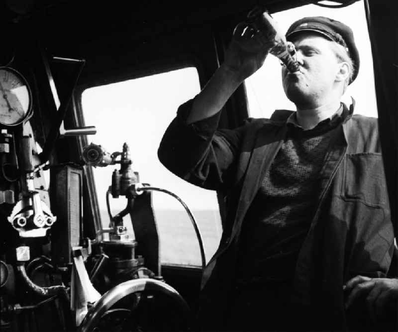 Shot of the engine driver Heinz Herre in the driver's cab of a class 41 1116 steam locomotive in Halberstadt in the state of Saxony-Anhalt in the area of the former GDR, German Democratic Republic