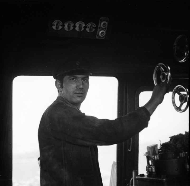 Portrait shot a stoker in the driver's cab of a class steam locomotive 41 1116 in Halberstadt in the state Saxony-Anhalt on the territory of the former GDR, German Democratic Republic