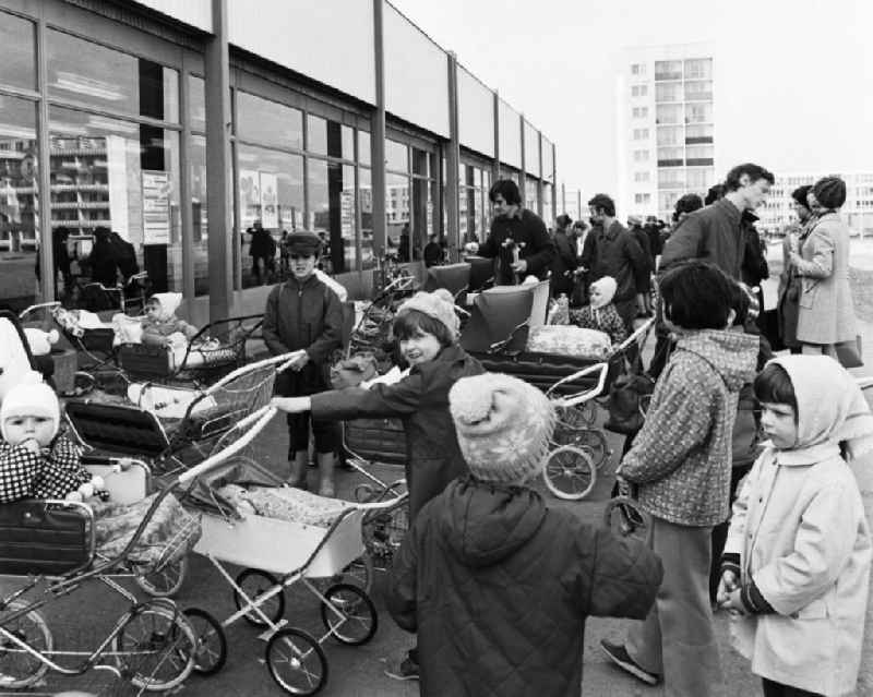 Große und kleine Kinder mit Kinderwagen und ihren Eltern an einer Kaufhalle im Wohngebiet Halle-Neustadt. Am Standort der Chemieindustrie der DDR wurde in den 1960er und 197