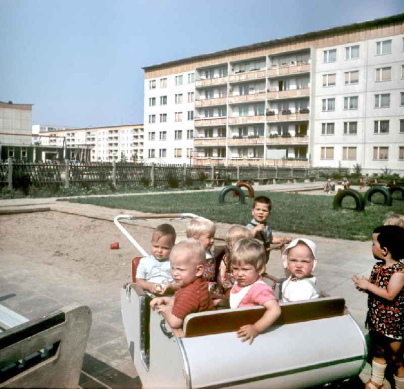 Eine Erzieherinn kümmert sich in einem Kindergarten in Halle-Neustadt um ein kleines Kind. Am Standort der Chemieindustrie der DDR wurde in den 1960er und 197