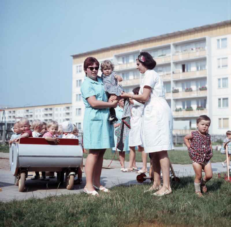 Zwei Erzieherinnen kümmern sich in einem Kindergarten in Halle-Neustadt um ein kleines Kind. Am Standort der Chemieindustrie der DDR wurde in den 1960er und 197
