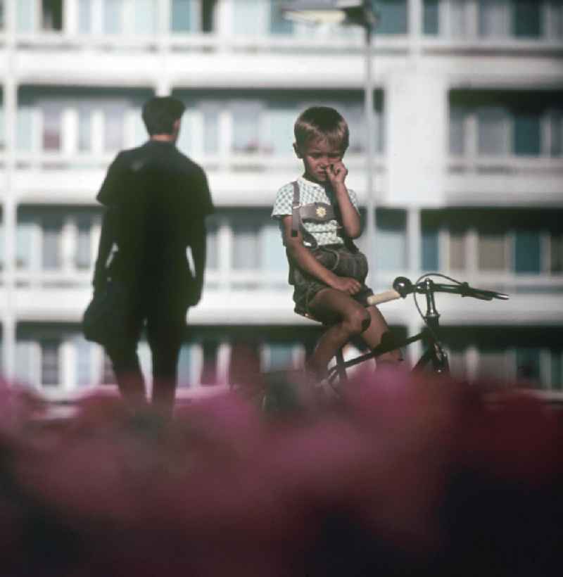 Ein Junge sitzt auf seinem Fahrrad und bohrt in der Nase in Halle-Neustadt. Am Standort der Chemieindustrie der DDR wurde in den 1960er und 197