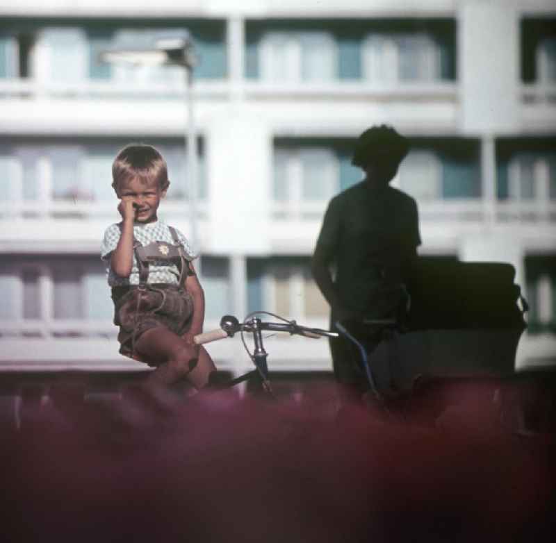 Ein Junge sitzt auf seinem Fahrrad und bohrt in der Nase in Halle-Neustadt. Am Standort der Chemieindustrie der DDR wurde in den 1960er und 197
