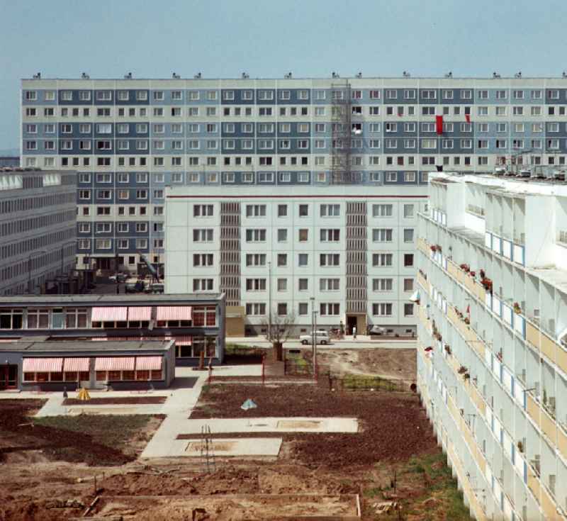Blick in ein Neubaugebiet in Halle-Neustadt mit Kindergarten und fertiggestellten Hochhäusern. Die Umgebung erinnert noch an eine Baustelle, aber die ersten Mieter sind schon in die fertigen Wohnhäuser eingezogen. Am Standort der Chemieindustrie der DDR wurde in den 1960er und 197