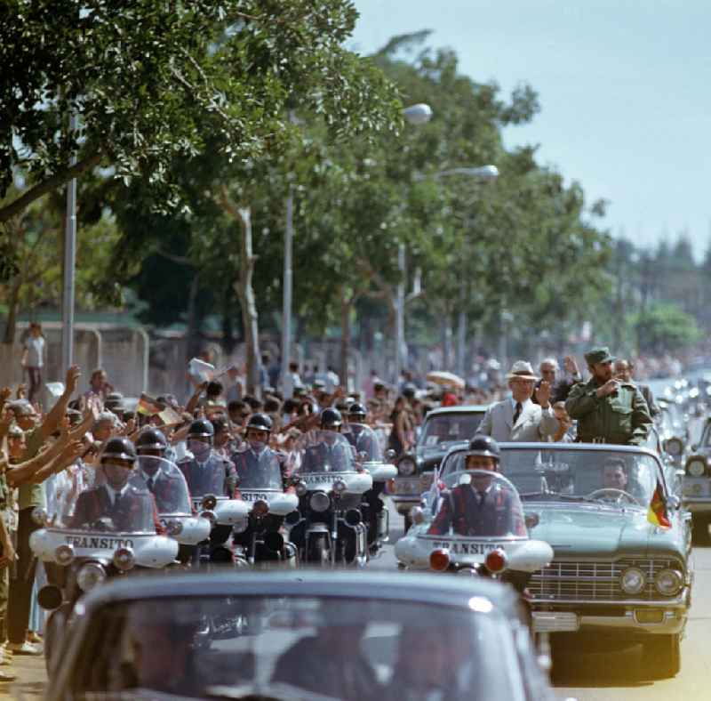 Mit großem Jubel, DDR-Fähnchen und Willkommens-Plakaten wird in der kubanischen Bevölkerung die Ankunft des Staats- und Parteivorsitzenden der DDR, Erich Honecker, in Havanna gefeiert - hier im Wagen mit dem Regierungschef Kubas Fidel Castro. Honecker stattete vom 2