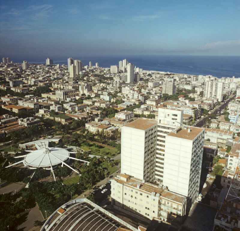 Blick über die Dächer der kubanischen Hauptstadt Havanna - historische Gebäude der Kolonialzeit wechseln mit Neubauten der sozialistischen Moderne. Links der Park rund um die futuristische Eisdiele Coppelia.