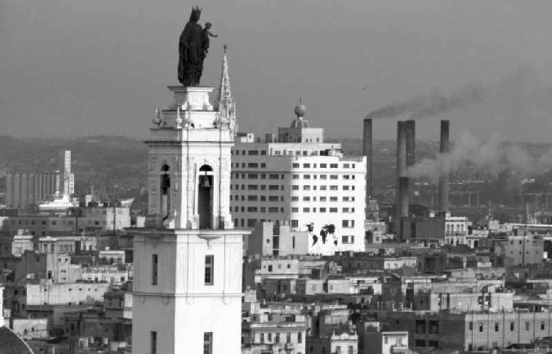 Blick über die Dächer der kubanischen Hauptstadt Havanna - historische Gebäude der Kolonialzeit wechseln mit Neubauten der sozialistischen Moderne. Links die Kirche Iglesia del Carmen de la calle Infanta.