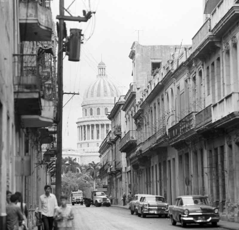 Straßenszene mit Blick auf das Kapitol in der historischen Altstadt von Havanna. Ursprünglich als Regierungssitz für den kubanischen Präsidenten gebaut, wird das Capitolio seit 1959 als öffentlich zugängliches Kongresszentrum genutzt.
