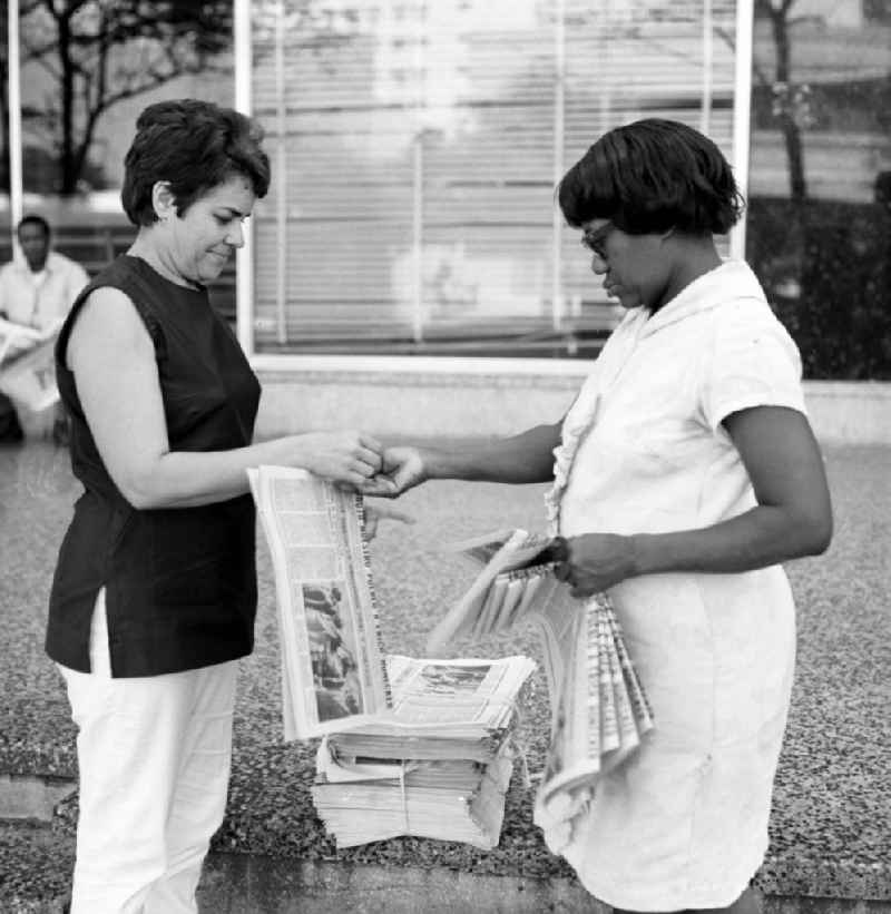 Eine Passantin kauft bei einer Zeitungsverkäuferin auf einer Straße in Havanna die aktuelle Ausgabe der 'Granma', der offiziellen Zeitung der Kommunistischen Partei Kubas (PCC). An diesem Tag ist die Zeitung voll mit Berichterstattungen und Fotos von der Ankunft des Staats- und Parteivorsitzenden der DDR, Erich Honecker, der vom 2