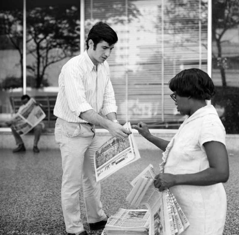 Ein Passant kauft bei einer Zeitungsverkäuferin auf einer Straße in Havanna die aktuelle Ausgabe der 'Granma', der offiziellen Zeitung der Kommunistischen Partei Kubas (PCC). An diesem Tag ist die Zeitung voll mit Berichterstattungen und Fotos von der Ankunft des Staats- und Parteivorsitzenden der DDR, Erich Honecker, der vom 2