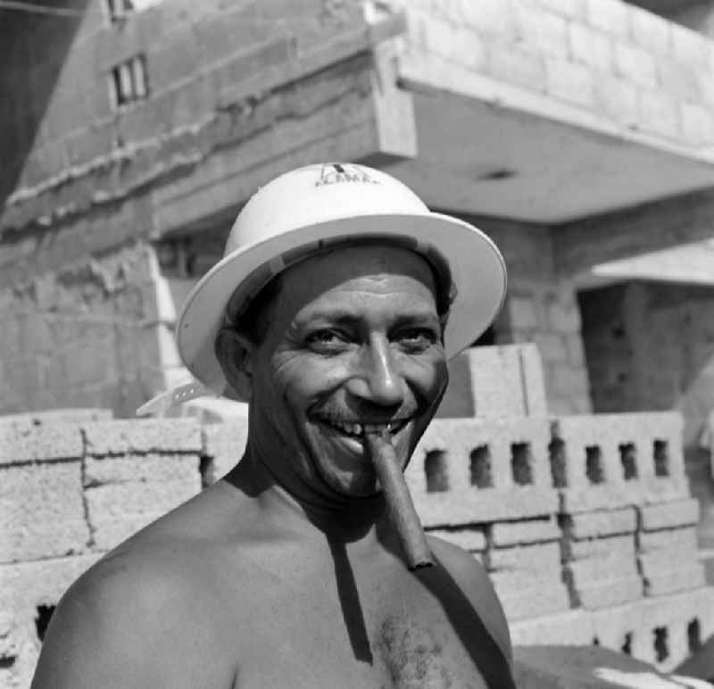 A master builder with a cigar on a construction site in the district Alamar in Havanna in Kuba