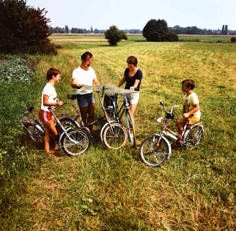 Family on a bike tour in Hoenow, Brandenburg on the territory of the former GDR, German Democratic Republic