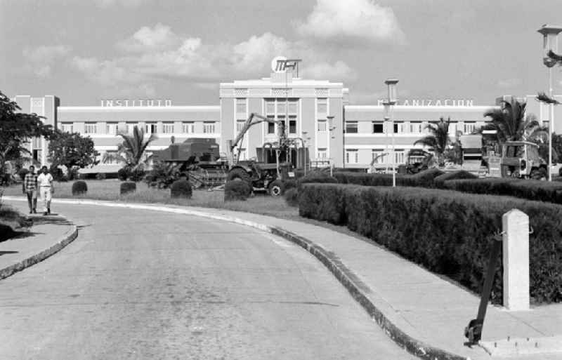 Blick auf das Instituto Mecanizacion bei Holguín in Kuba. Landwirtschaftliche Großgeräte vor dem Institutsgebäude zur Mechnisierung der Landwirtschaft zeugen davon, dass in den 7