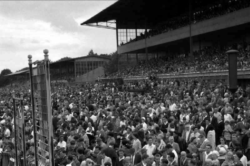Spectators in front of and on the main grandstand of the racecourse in Hoppegarten in the state Brandenburg on the territory of the former GDR, German Democratic Republic