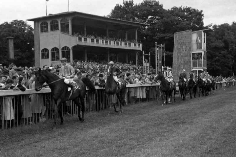 Horses and jockeys at the parade in front of the grandstand of the racecourse in Hoppegarten in the state Brandenburg on the territory of the former GDR, German Democratic Republic