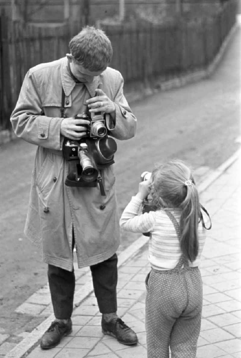 Gegenseitig fotografieren sich ein Mädchen und ein Mann beim Fotografieren.