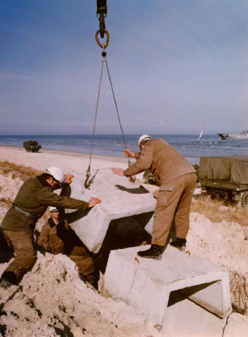 Assembly and installation work of concrete segments by building pioneer soldiers of the NVA of the GDR at the dunes area of ??the beach of the Baltic Sea near Karlshagen in present-day Mecklenburg-Vorpommern