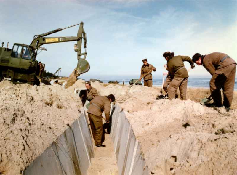 Assembly and installation work of concrete segments by building pioneer soldiers of the NVA of the GDR at the dunes area of ??the beach of the Baltic Sea near Karlshagen in present-day Mecklenburg-Vorpommern
