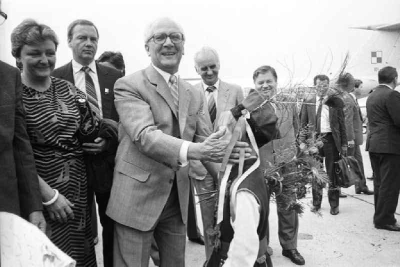 Staatsbesuch von Erich Honecker, Staatsratsvorsitzender in der Volksrepublik Polen. Honecker bekommt von kleinen Junge / Kind in Volkstracht einen Blumenstrauß überreicht. Beiligte stehen drumherum. Im Hintergrund Passagierflugzeug Tupolew TU-134.
