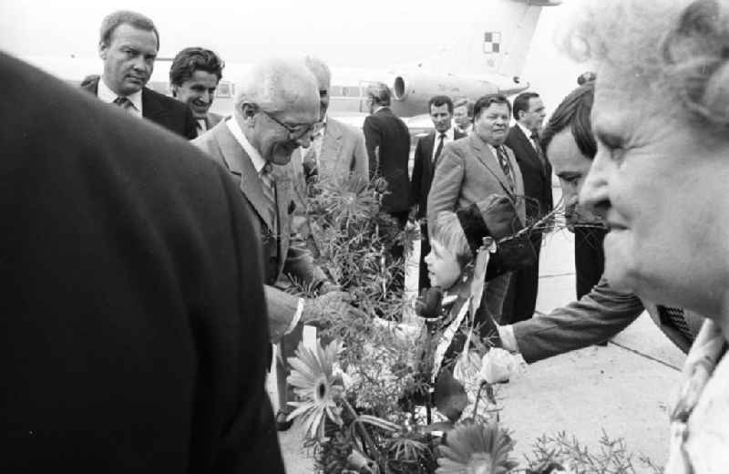 Staatsbesuch von Erich Honecker, Staatsratsvorsitzender in der Volksrepublik Polen. Honecker bekommt von kleinen Junge / Kind in Volkstracht einen Blumenstrauß überreicht. Beiligte stehen drumherum. Im Hintergrund Passagierflugzeug Tupolew TU-134.