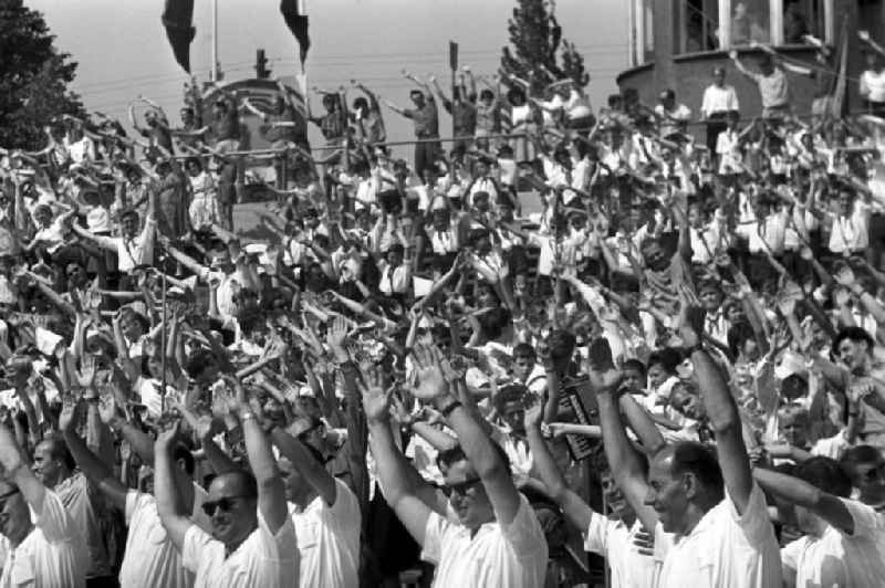 Zuschauer schwenken begeistert ihre Arme beim IV. Deutschen Turn- und Sportfest in Leipzig vom 1.-4.8.1963 im Takt.