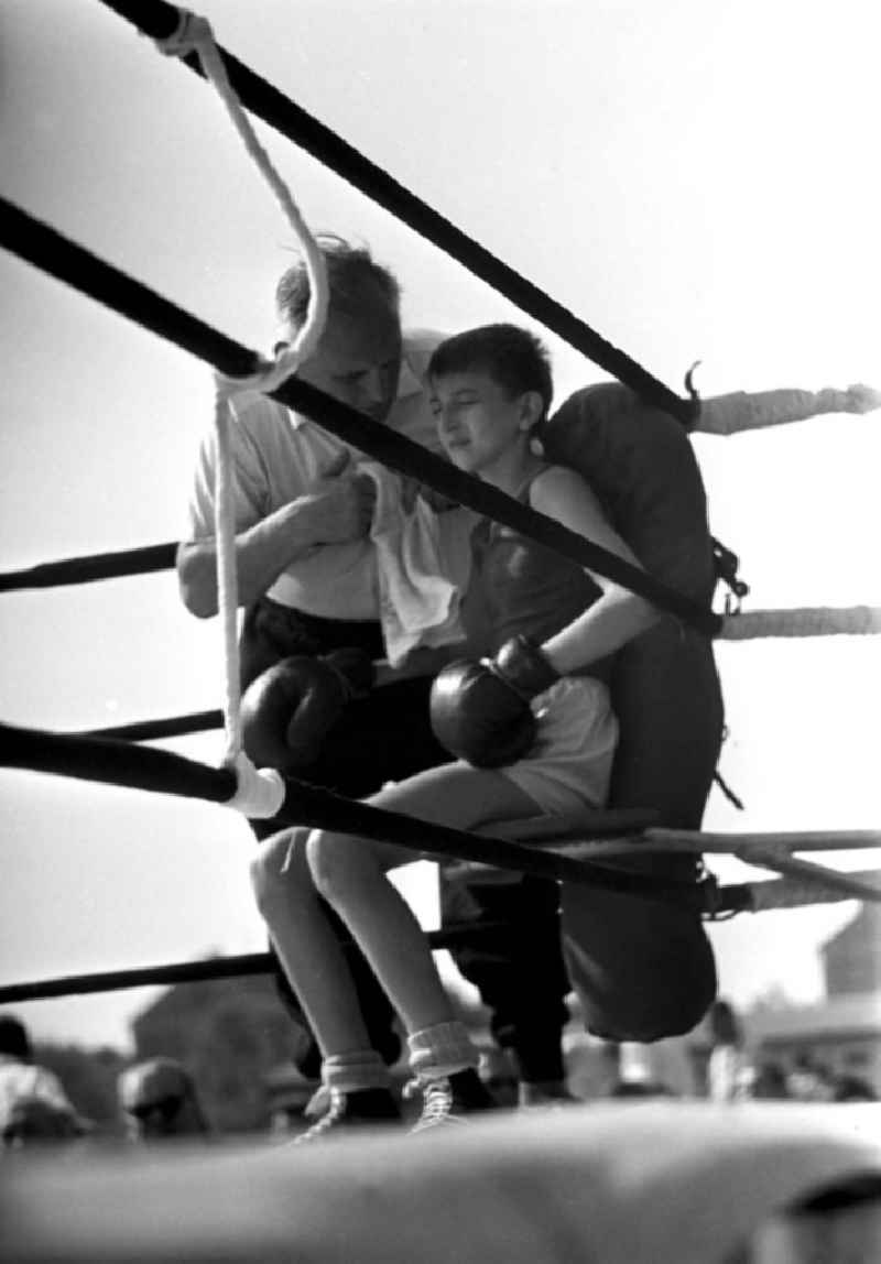 Ein Junge wird von seinem Trainer auf den nächsten Boxkampf beim IV. Deutschen Turn- und Sportfest in Leipzig vom 1.-4.8.1963 vorbereitet.